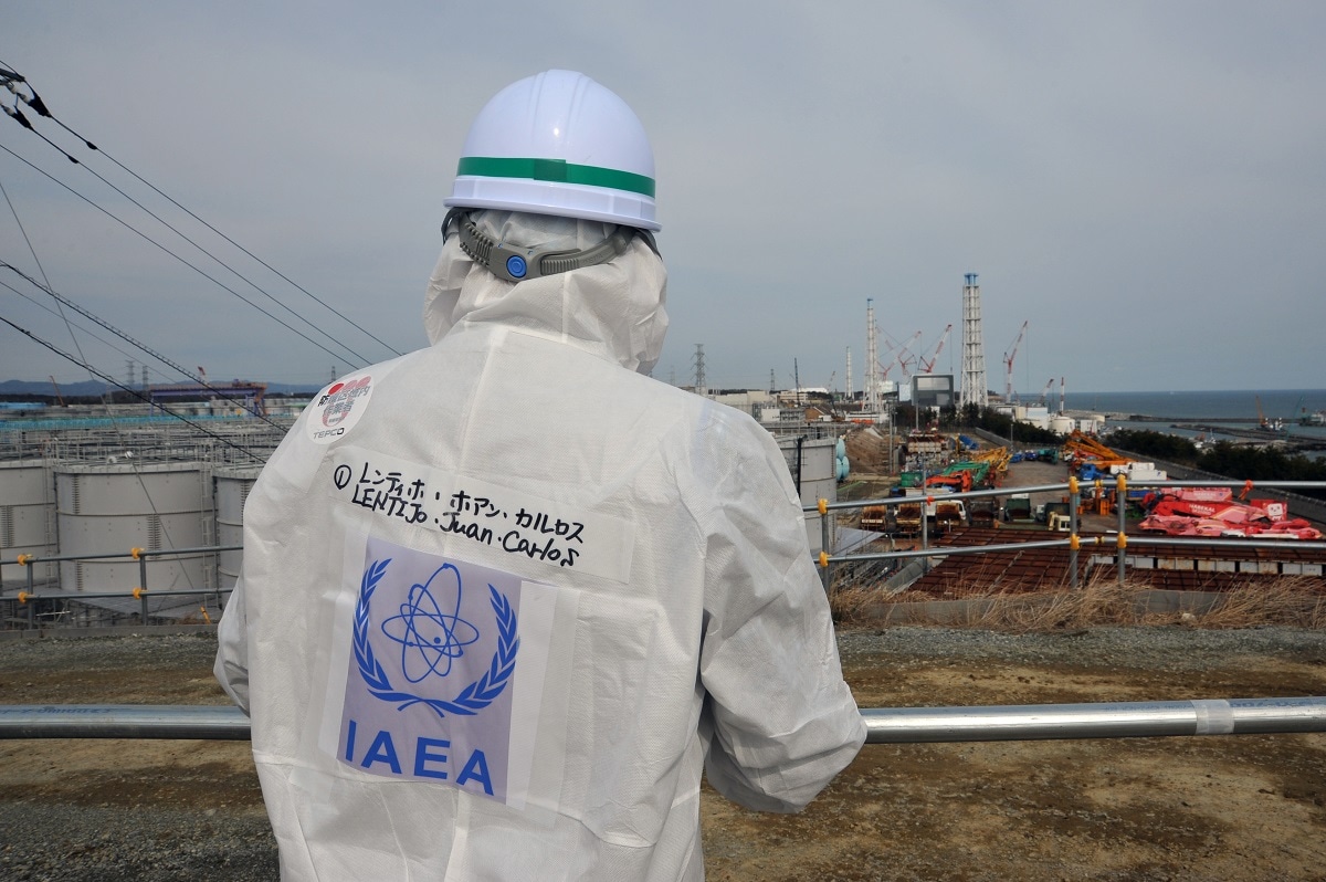 IAEA ImagebankFollow Fukushima Daiichi Nuclear Power Station (02110041) Juan Carlos Lentijo, team leader for an IAEA mission to review Japan's plans and work to decontaminate the Fukushima Daiichi Nuclear Power Station, looks at tanks holding contaminated water and the Unit 4 and Unit 3 reactor buildings during a tour of the tsunami-stricken nuclear power plant. . 11 February 2015     Photo Credit: Susanna Loof / IAEA